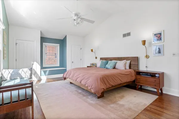 a bedroom with a bed and wooden floor