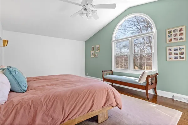 a bedroom with a large bed and a chandelier