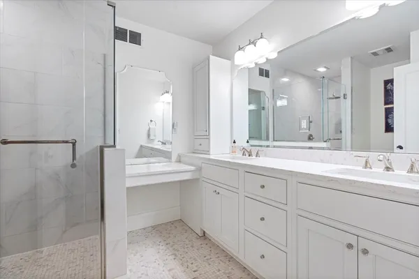 a bathroom with double vanity sinks and a mirror
