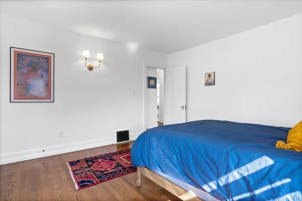a bedroom with a bed and painting on the wall