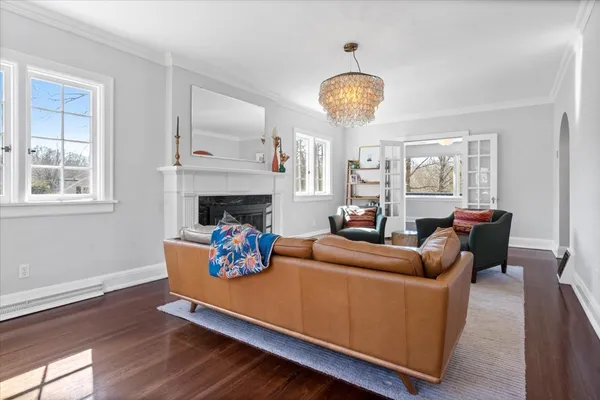 a living room with furniture a chandelier and a fireplace