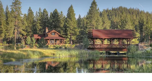 a view of house with river and trees in the background
