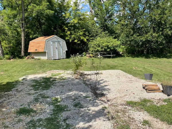 a front view of a house with a yard and trees