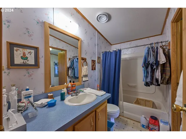 a bathroom with a sink vanity granite and a shower