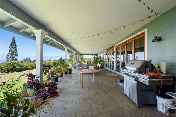 a view of a porch with chairs and potted plants