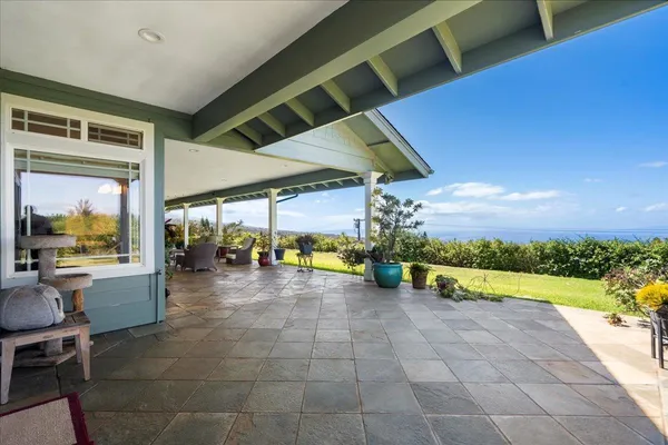 a view of a patio with a table and chairs under an umbrella