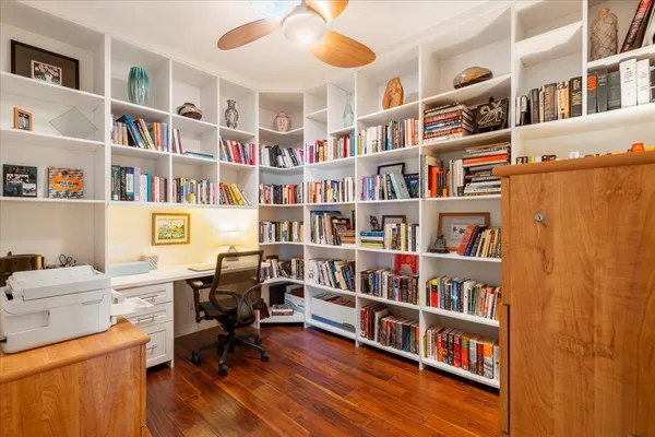 a view of a workspace with bookshelf and a workspace