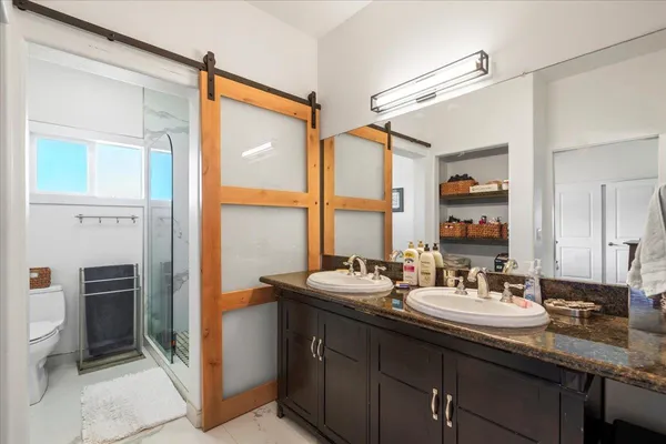 a bathroom with a double vanity sink a mirror and a shower