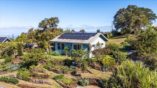 a view of a house with a big yard and large trees