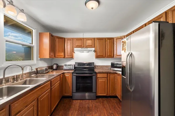 a kitchen with stainless steel appliances granite countertop a sink stove and refrigerator