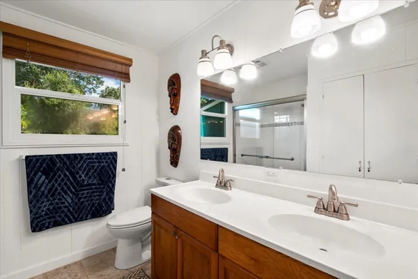 a bathroom with a sink a toilet and a mirror