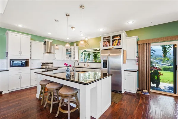 a kitchen with stainless steel appliances granite countertop a sink and a refrigerator