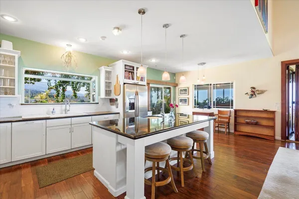 a kitchen with stainless steel appliances kitchen island granite countertop a sink and cabinets