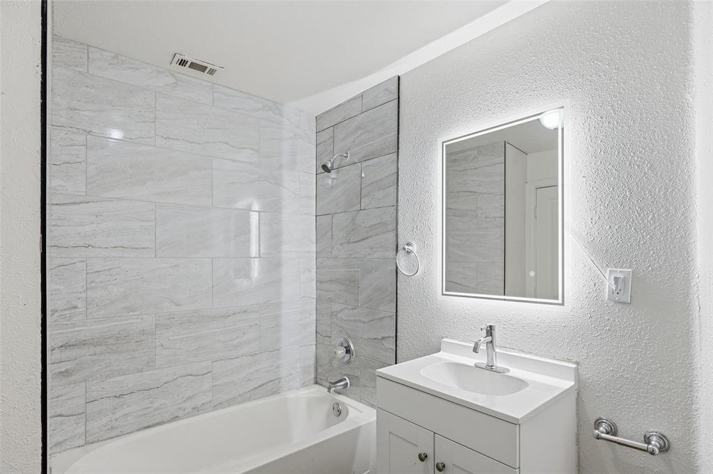 4310 Utah Avenue Dallas, TX 75216 - Photo 3 of 14 a bathroom with a sink mirror and a bathtub