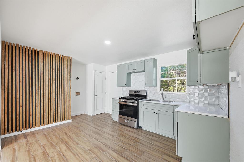 4310 Utah Avenue Dallas, TX 75216 - Photo 9 of 14 a kitchen with stainless steel appliances kitchen island granite countertop a stove a sink and a refrigerator