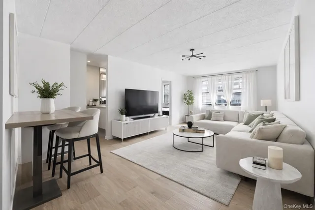 a living room with furniture a flat screen tv and a window