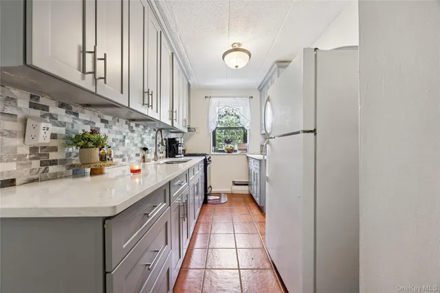 a kitchen with stainless steel appliances a refrigerator a sink a stove and white cabinets