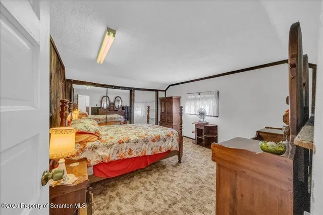 a bedroom with a bed table flowerpot and window