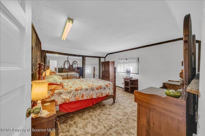 10846 Forest Lake Road Montrose, PA 18801 - Photo 22 of 42 a bedroom with a bed table flowerpot and window