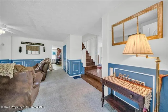a living room with furniture a flat screen tv and a large window