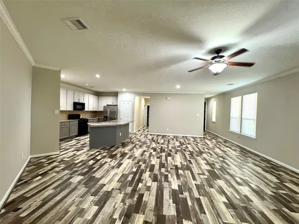 a open kitchen with kitchen island a stove a sink and a refrigerator