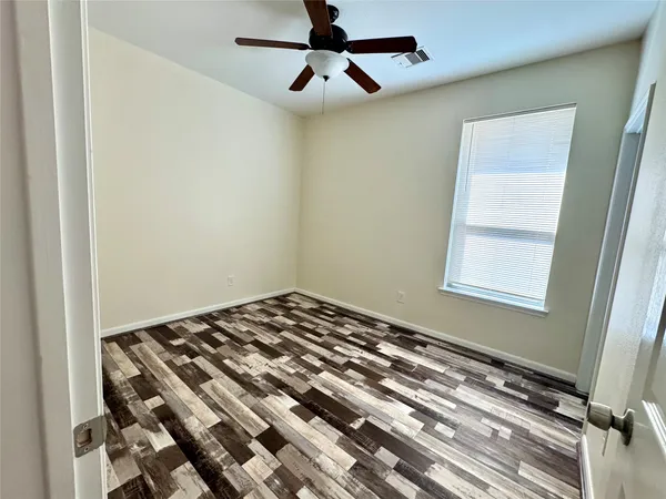 a bedroom with bed and wooden floor