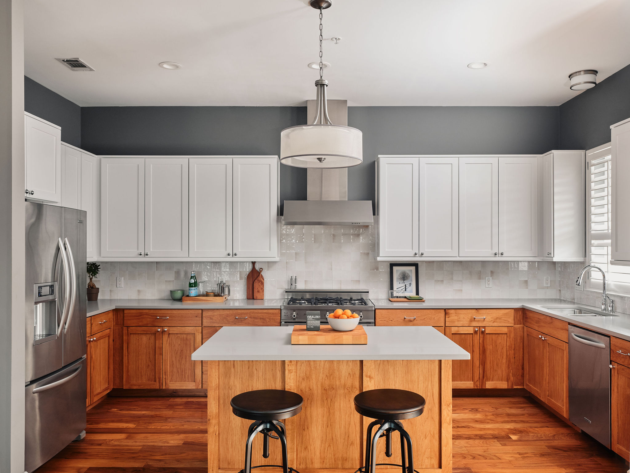 1504 Collier Street, Unit 4 Austin, TX 78704 - Photo 2 of 38 Kitchen with stainless steel appliances, dark wood-style flooring, a kitchen island, decorative light fixtures, and a kitchen breakfast bar