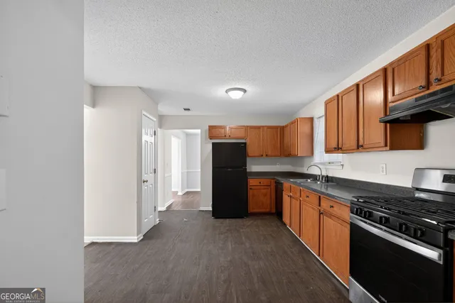 a kitchen with a refrigerator and a stove top oven