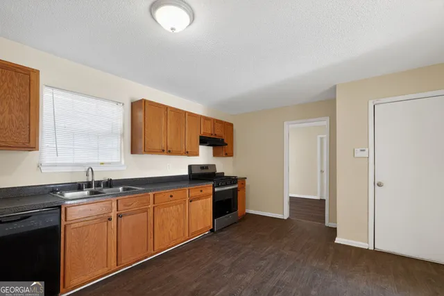 a kitchen with a sink stove and cabinets