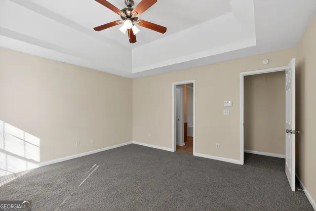 an empty room with chandelier fan