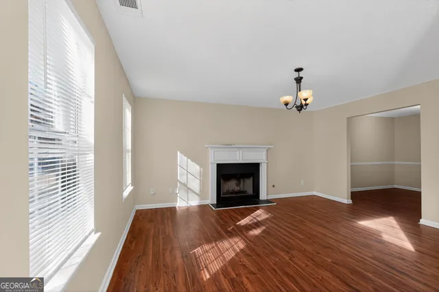 a view of empty room with wooden floor and fireplace