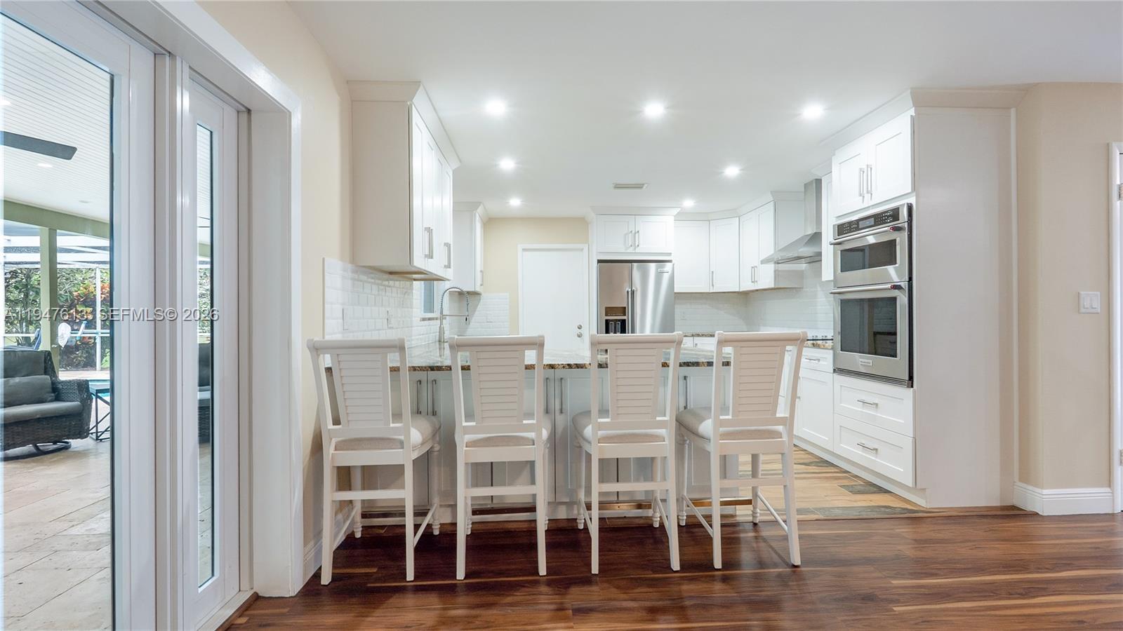 11071 Southwest 30th Court Davie, FL 33328 - Photo 11 of 44 a kitchen with stainless steel appliances kitchen island granite countertop a refrigerator and white cabinets