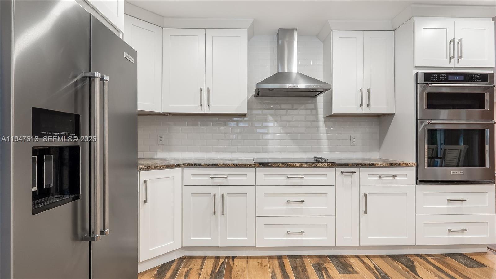11071 Southwest 30th Court Davie, FL 33328 - Photo 7 of 44 a kitchen with white cabinets and stainless steel appliances