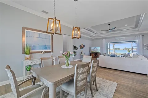 a kitchen with granite countertop a table chairs stainless steel appliances and wooden floor