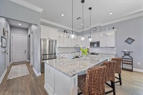 a kitchen with stainless steel appliances granite countertop a stove cabinets and wooden floor