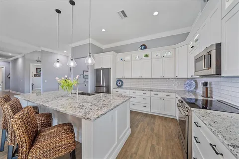 a work place with stainless steel appliances granite countertop furniture and a flat screen tv