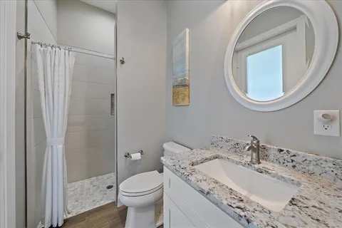 a bathroom with a granite countertop double vanity sink and a mirror