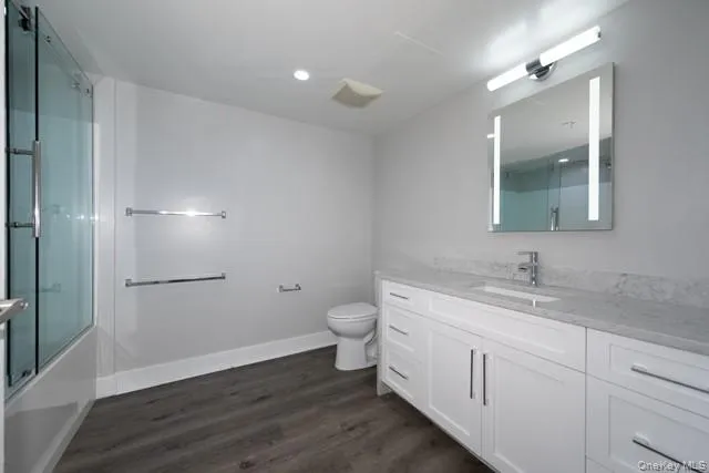 a bathroom with a toilet a sink and mirror