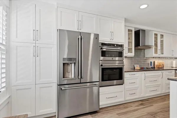 a kitchen with stainless steel appliances white cabinets and a refrigerator