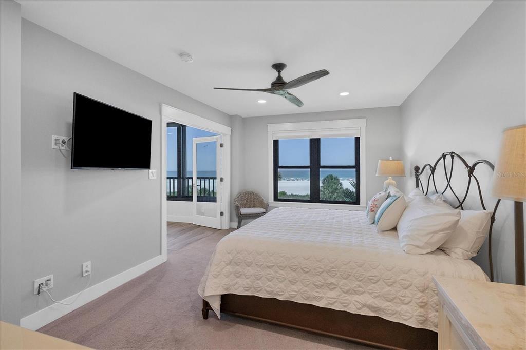 5740 Midnight Pass Road, Unit 303F Sarasota, FL 34242 - Photo 21 of 51 a bedroom with a large bed and a flat screen tv