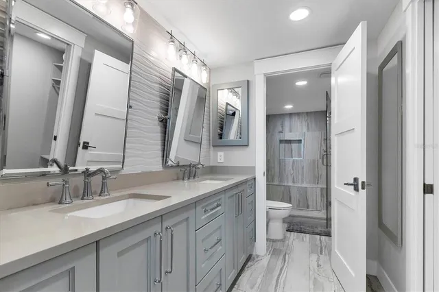 a bathroom with a granite countertop sink double vanity and a mirror