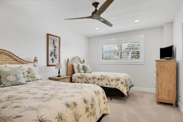 a bedroom with two beds and a flat screen tv