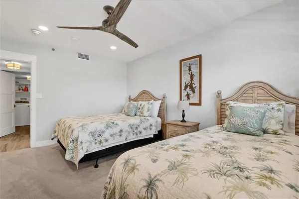 a bedroom with two beds and a chandelier