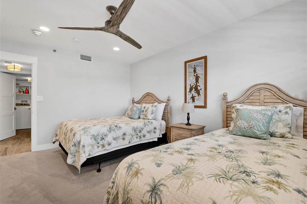 5740 Midnight Pass Road, Unit 303F Sarasota, FL 34242 - Photo 30 of 51 a bedroom with two beds and a chandelier