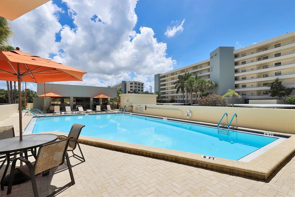5740 Midnight Pass Road, Unit 303F Sarasota, FL 34242 - Photo 32 of 51 a swimming pool with outdoor seating and yard