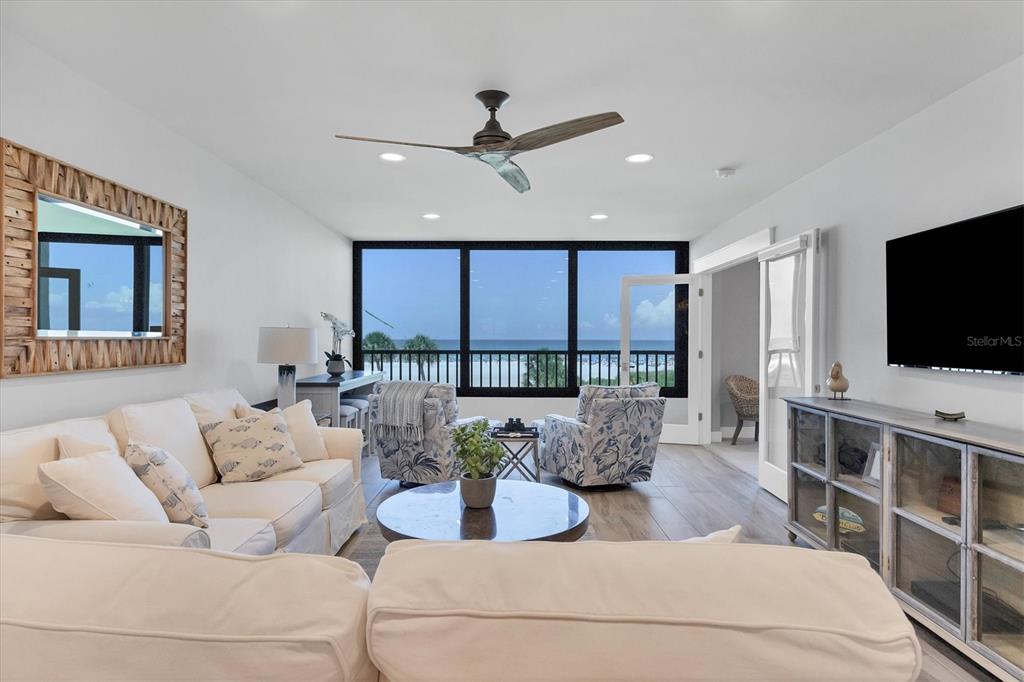 5740 Midnight Pass Road, Unit 303F Sarasota, FL 34242 - Photo 6 of 51 a living room with furniture and a flat screen tv