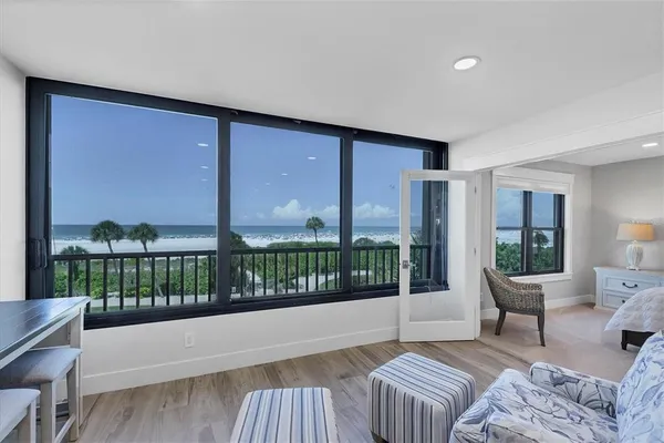 a spacious bedroom with a large window and a balcony