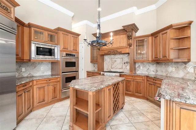 a kitchen with stainless steel appliances granite countertop a stove top oven a sink dishwasher and a microwave oven on the blue kitchen countertops