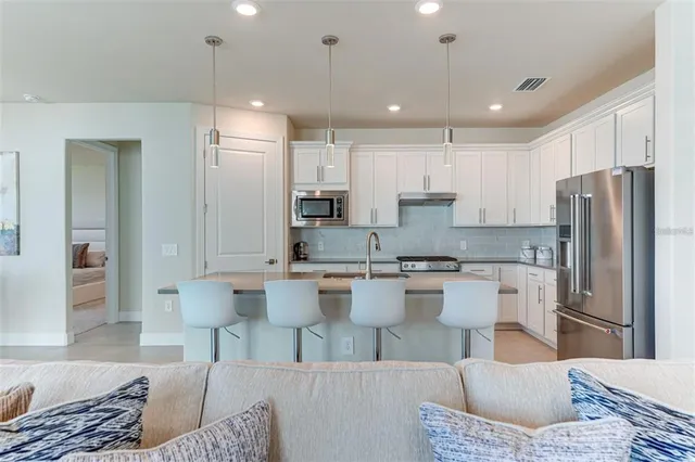 a kitchen with stainless steel appliances granite countertop a sink dishwasher stove and refrigerator with wooden cabinets