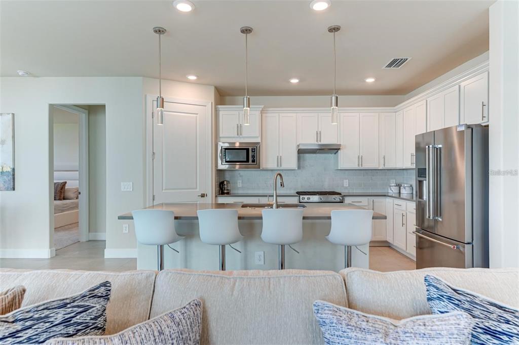 18023 Waterville Place Lakewood Ranch, FL 34202 - Photo 15 of 41 a kitchen with white cabinets and stainless steel appliances